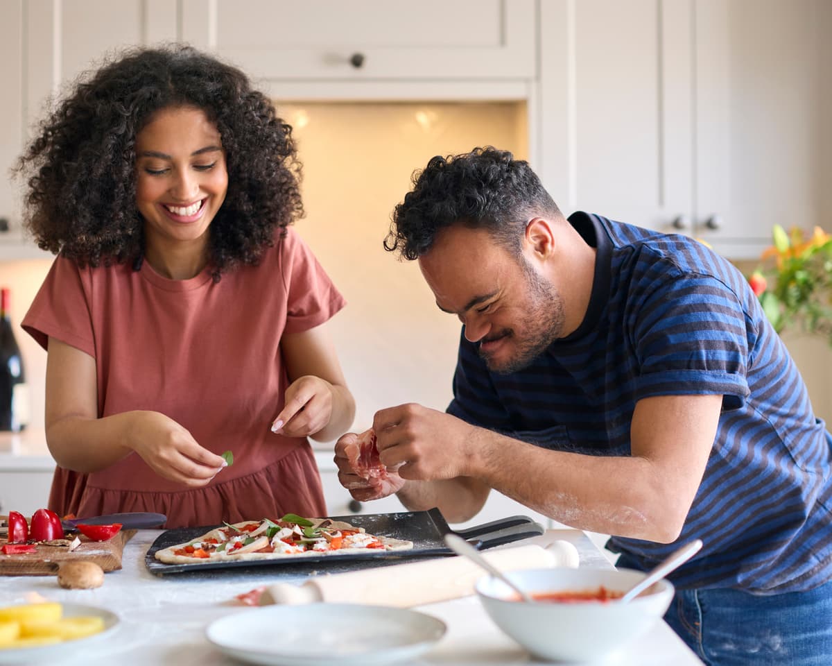 Woman and disabled man baking pizza