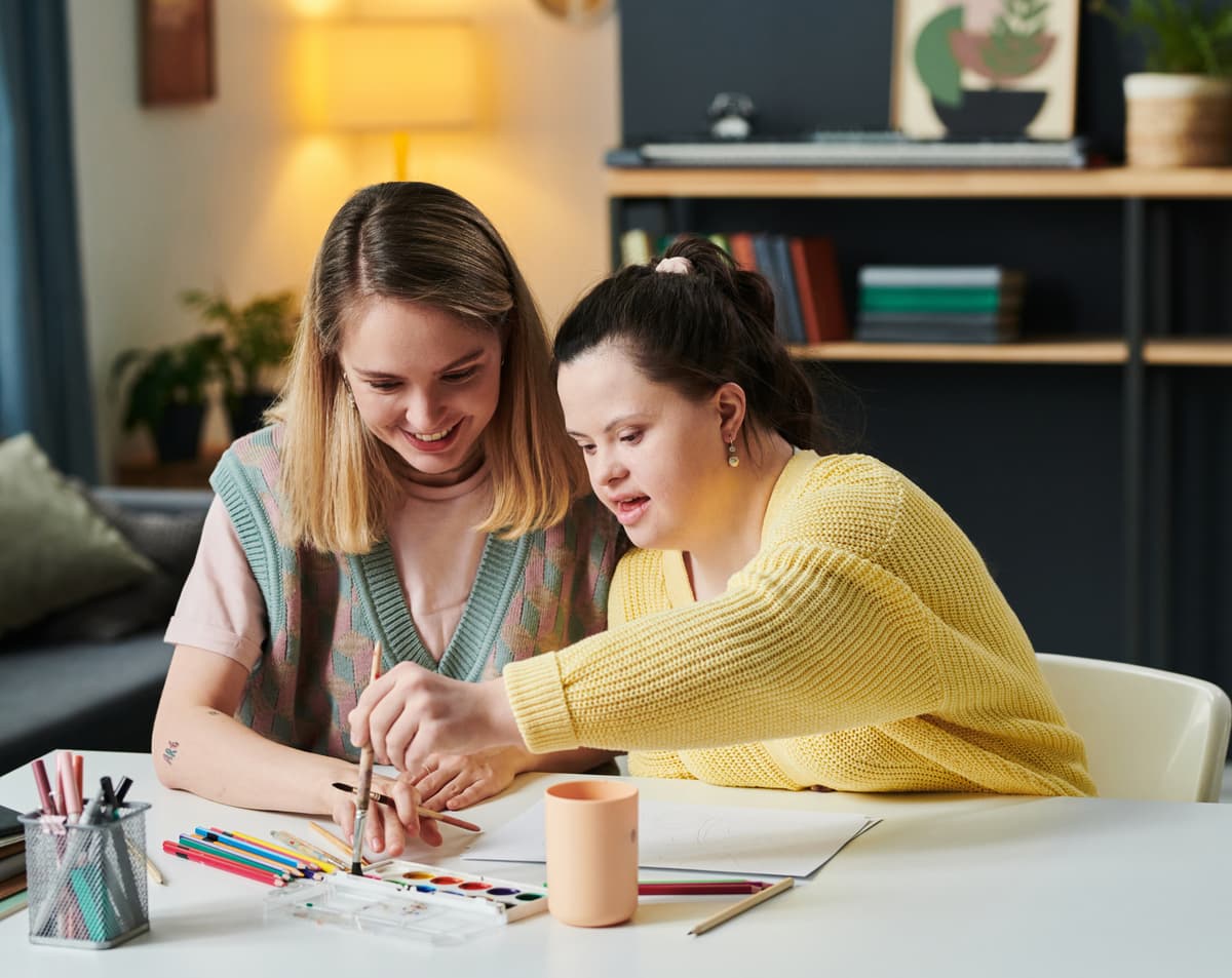 Woman with child drawing with paints
